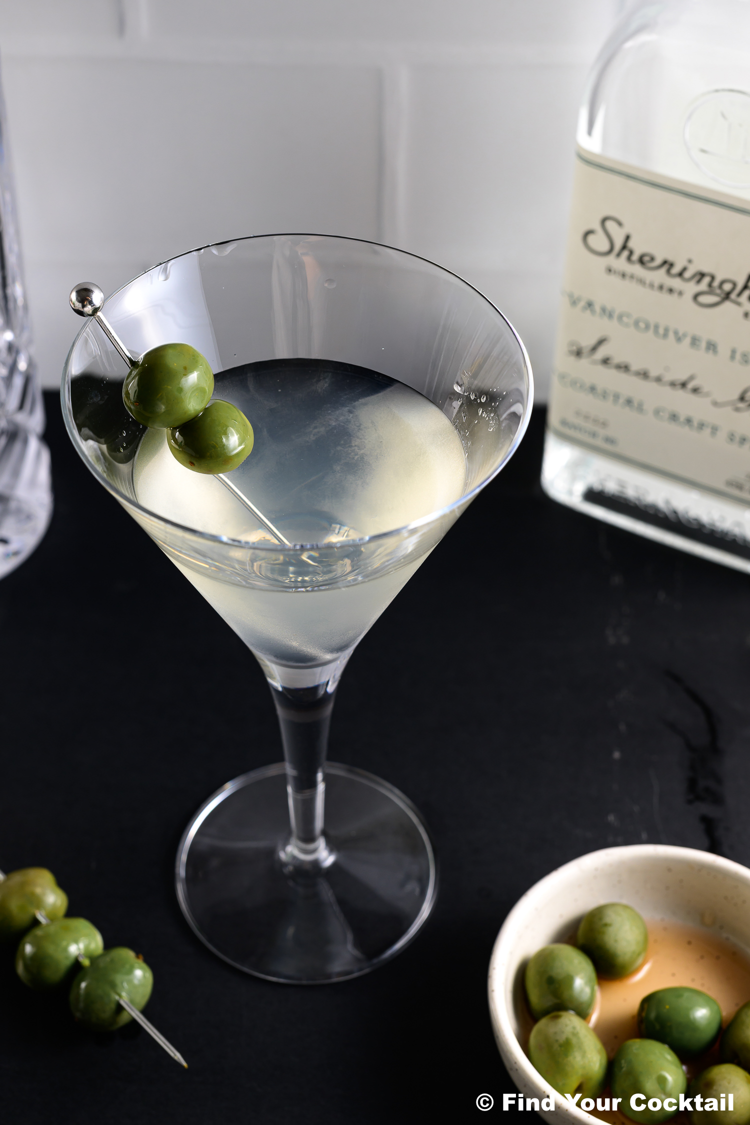 looking down on a martini glass with olive garnish