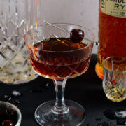 A Manhattan in a coupe glass with a brandy cherry garnish