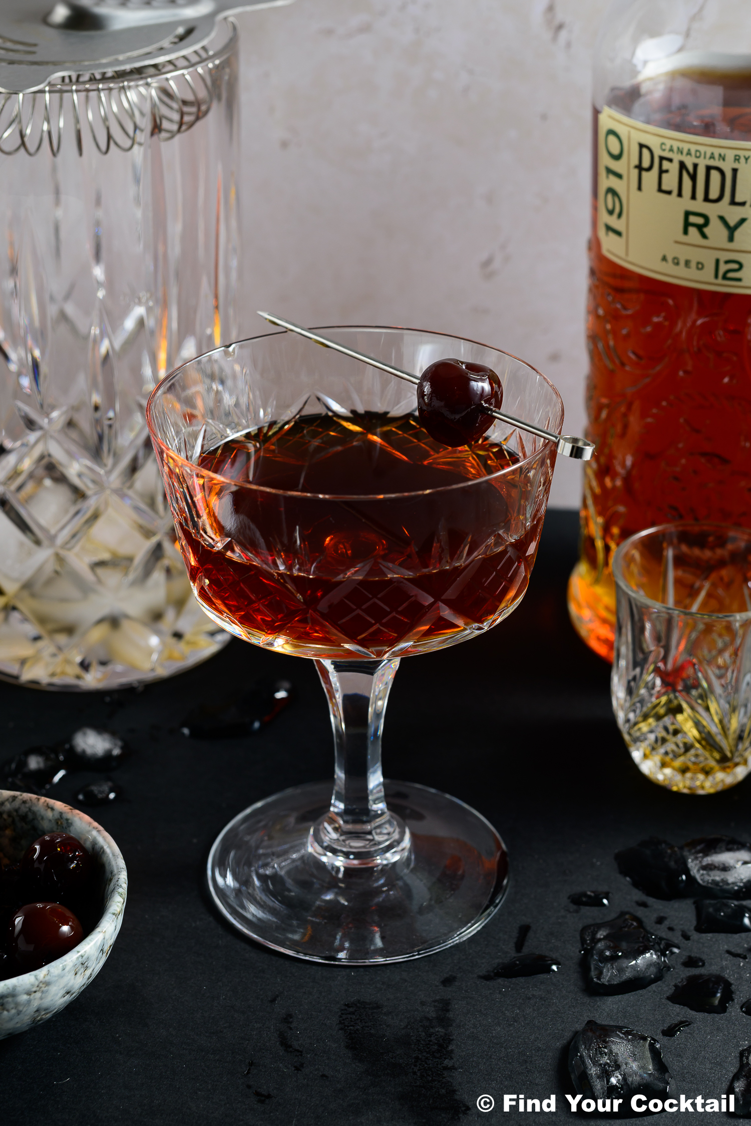 A Manhattan in a coupe glass with a brandy cherry garnish