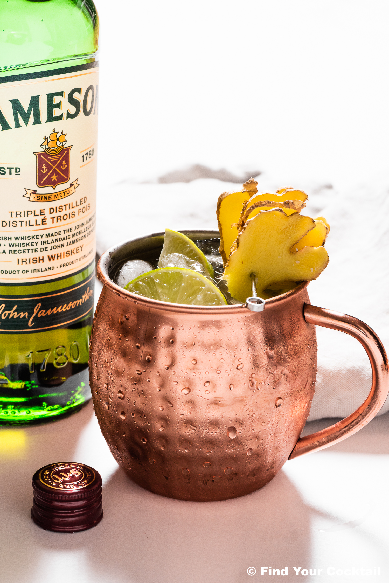 An Irish mule in a copper mule mug with a bottle of Jameson Whiskey in the back