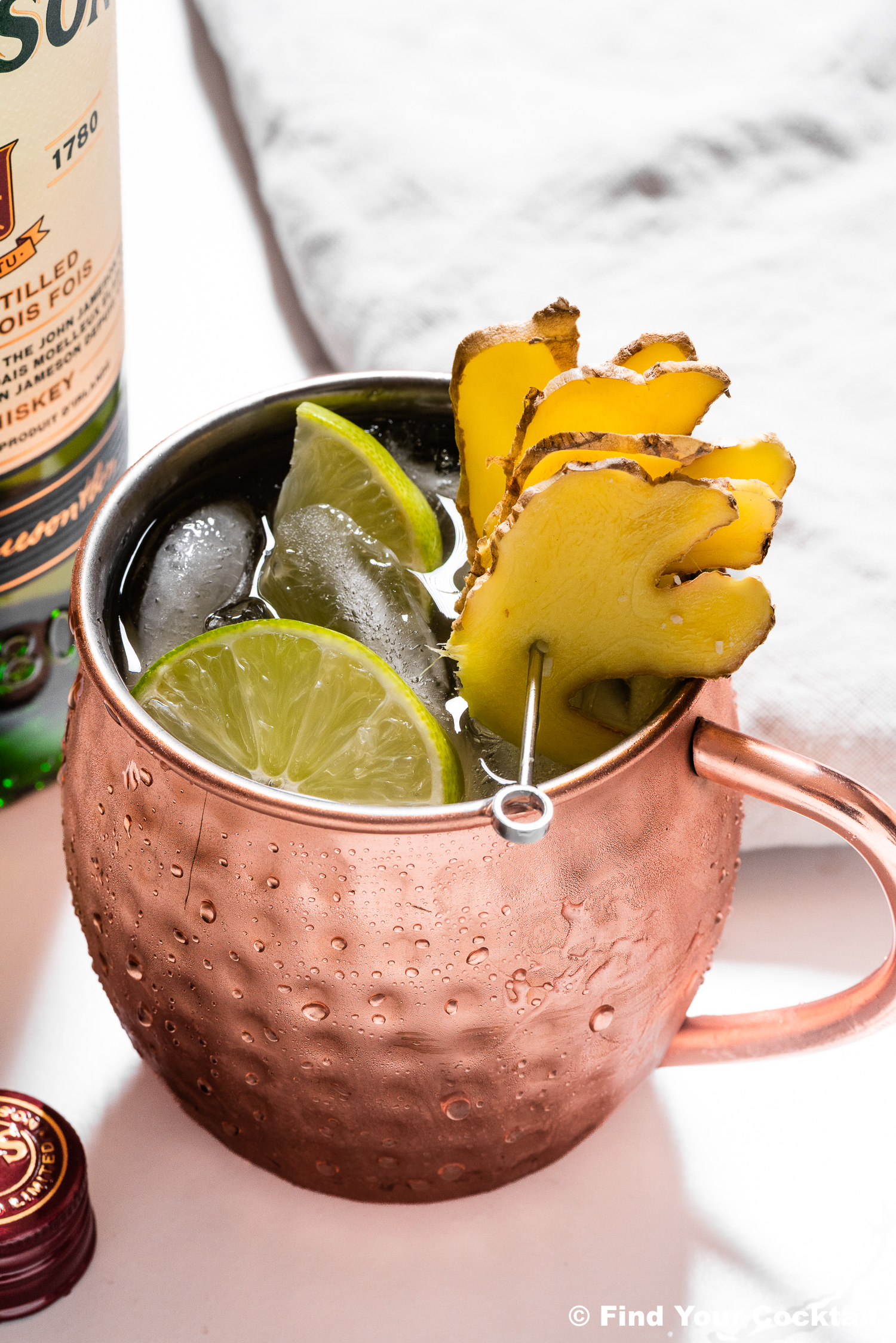 An Irish mule garnished with lime slices and ginger slices. 