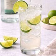 Topo Chico being poured into a tall glass of ranch water.