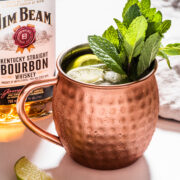 a mule mug with a bottle of bourbon in the background.