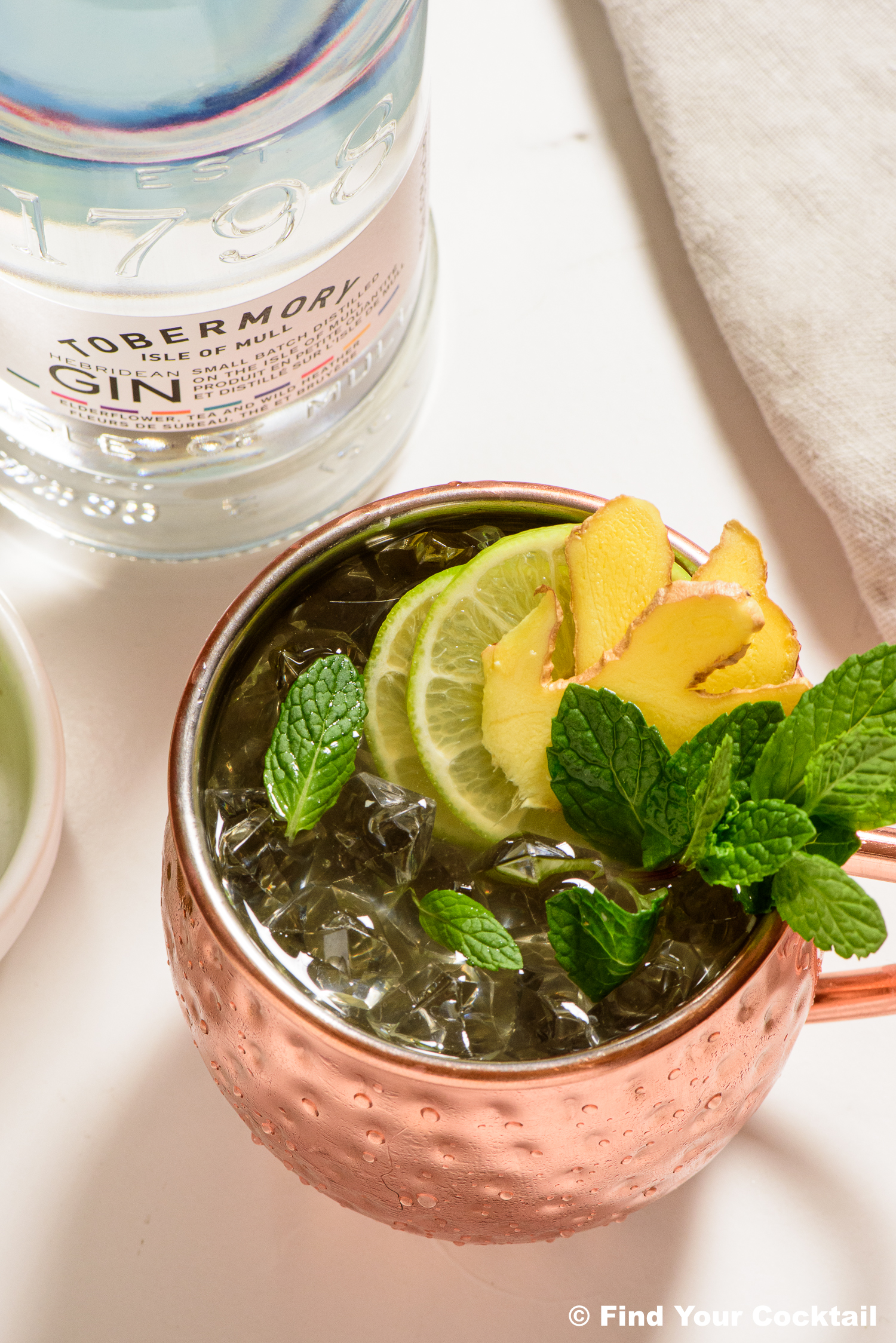 looking down on a copper mule mug with a bottle of gin beside it