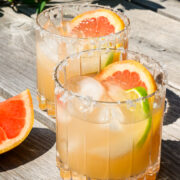 2 grapefruit margaritas on a table outside in the sun