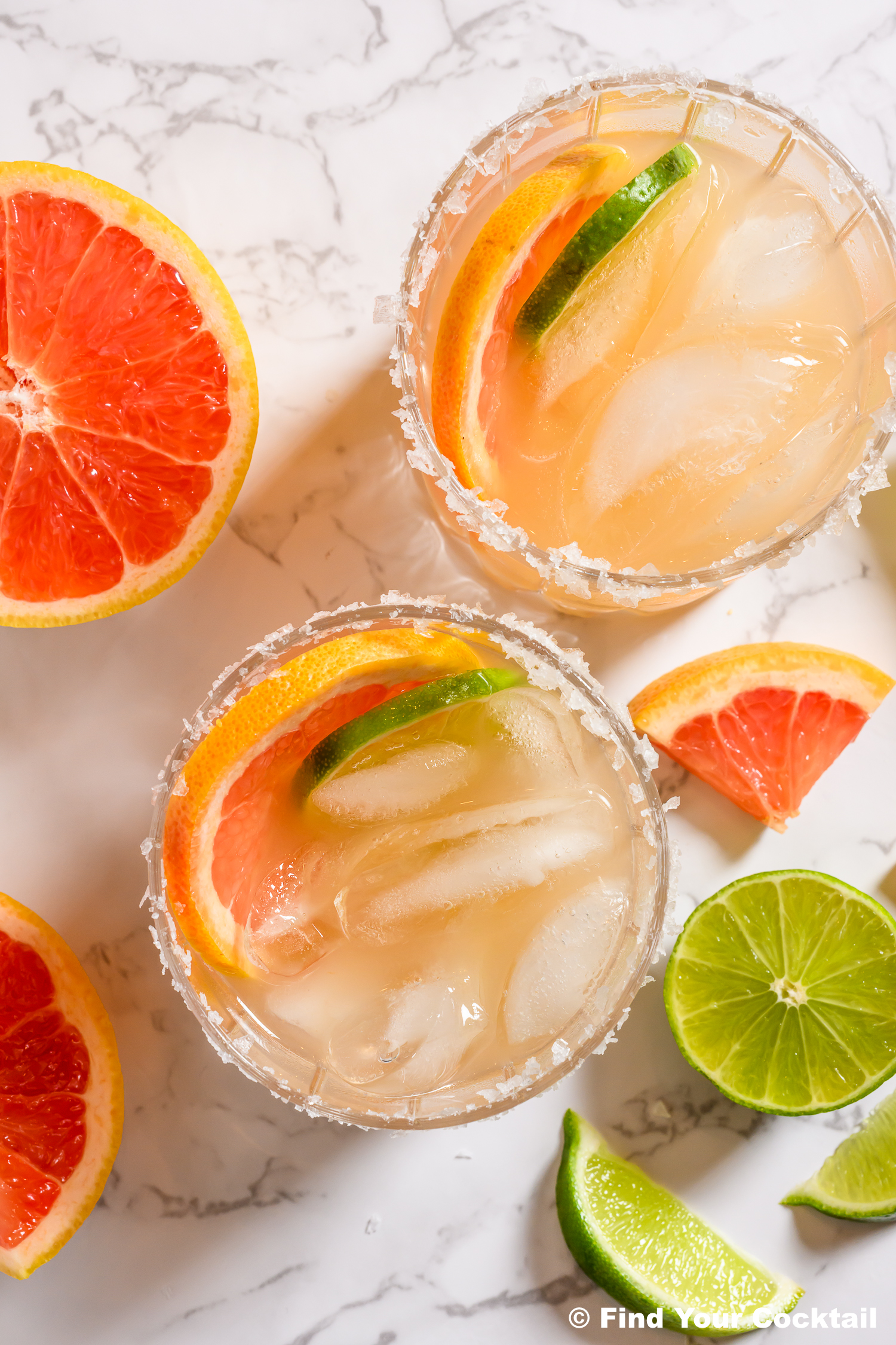 looking down on two margaritas with grapefruit and lime.