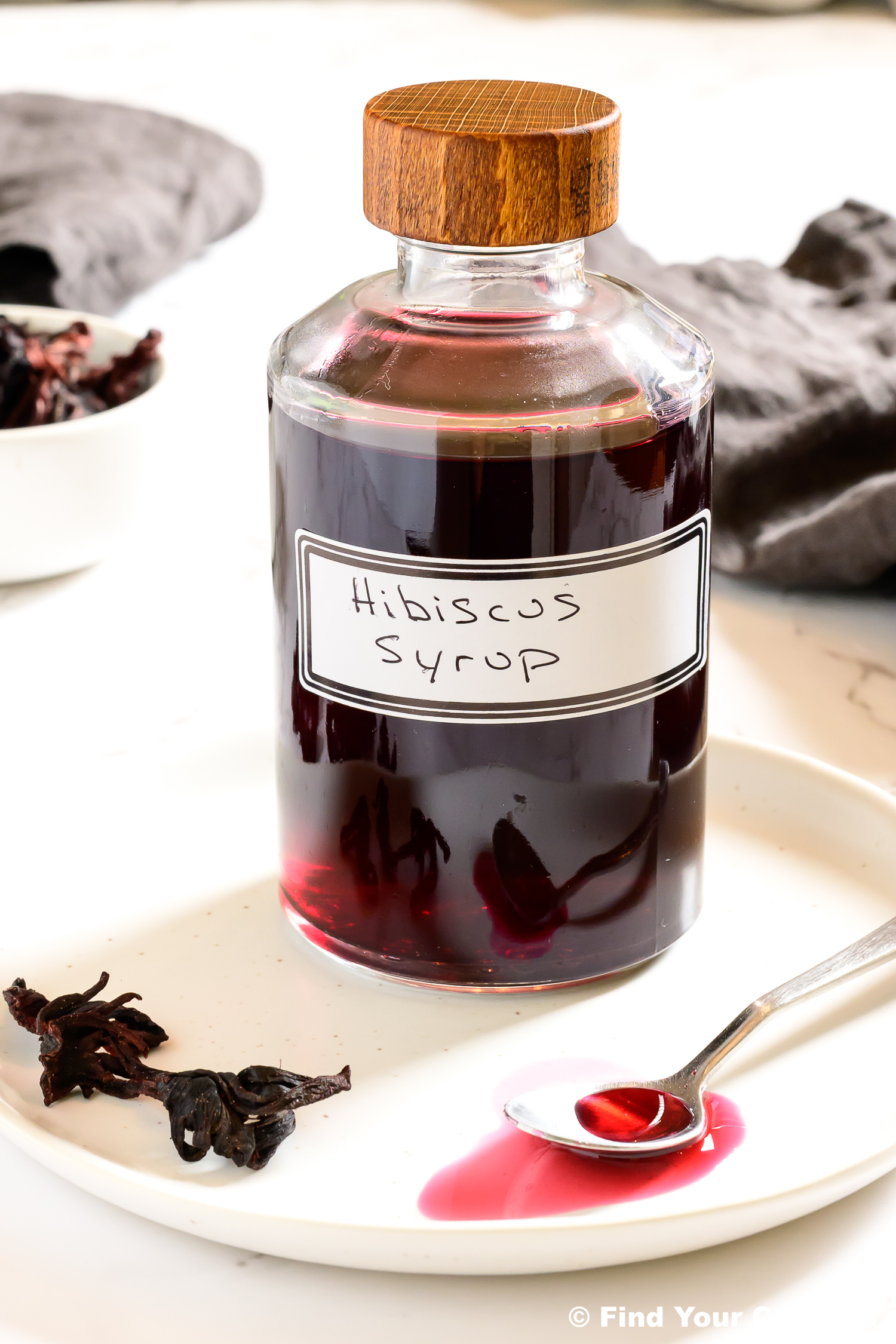 a jar with a wooden top labeled hibiscus syrup