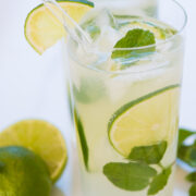 a mojito in a tall glass with mint and lime